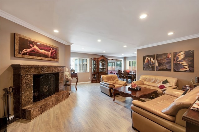 living room with light wood-type flooring, a premium fireplace, and ornamental molding