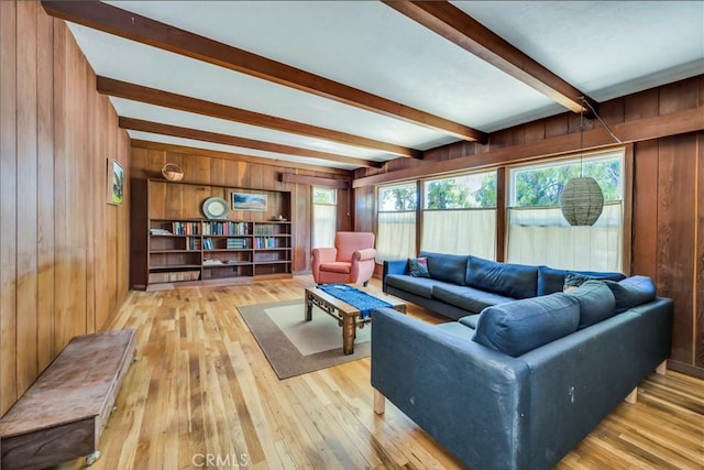 living room featuring beam ceiling, light hardwood / wood-style flooring, and wooden walls