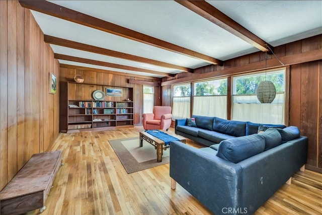 living area featuring beamed ceiling, wood walls, and wood-type flooring