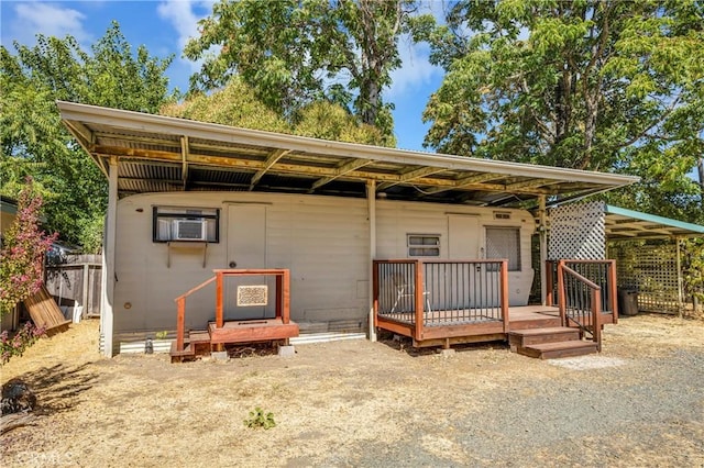 rear view of house with a carport and a wooden deck