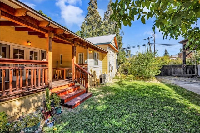 view of yard with central air condition unit and a wooden deck