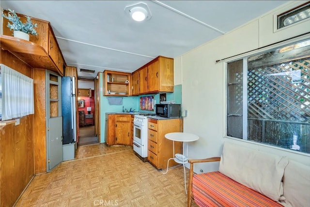 kitchen with stainless steel fridge, white gas range, and light parquet floors