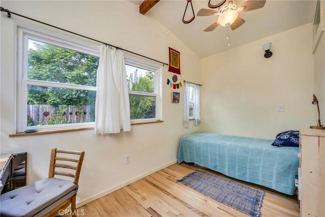 bedroom featuring vaulted ceiling with beams, ceiling fan, light hardwood / wood-style floors, and multiple windows