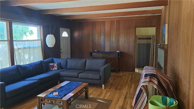 living room with beamed ceiling, hardwood / wood-style flooring, and wood walls