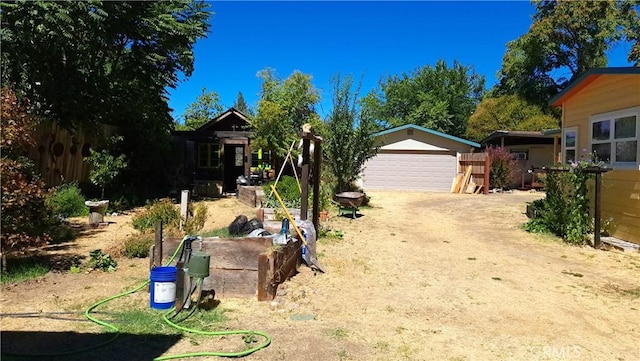 exterior space featuring an outbuilding, a garage, and dirt driveway