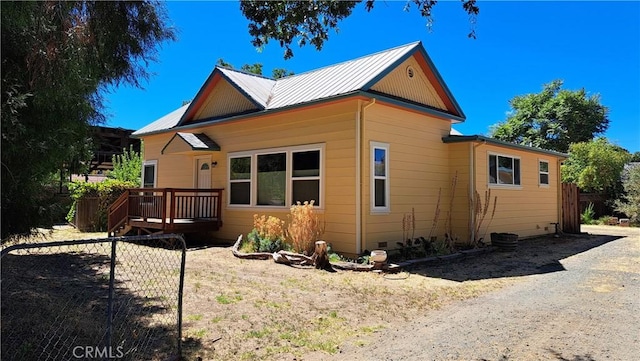 view of side of home featuring a wooden deck and metal roof