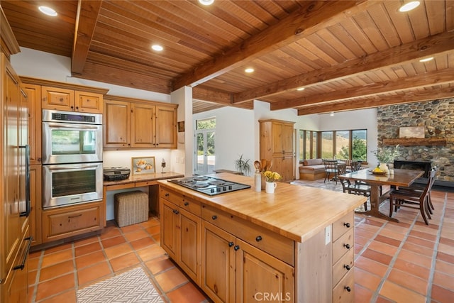 kitchen featuring appliances with stainless steel finishes, wood ceiling, wood counters, and plenty of natural light