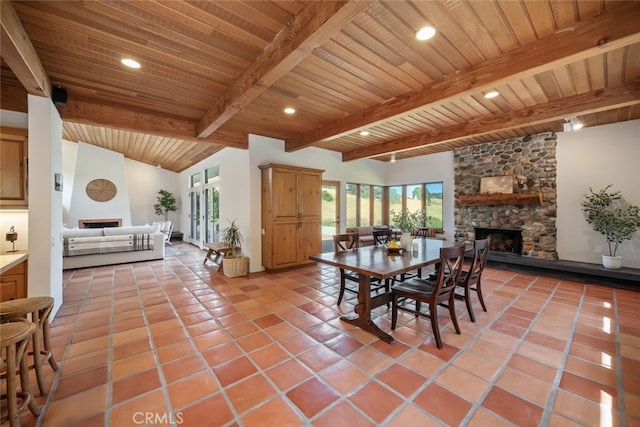 dining area featuring light tile patterned flooring, a fireplace, lofted ceiling with beams, and wood ceiling