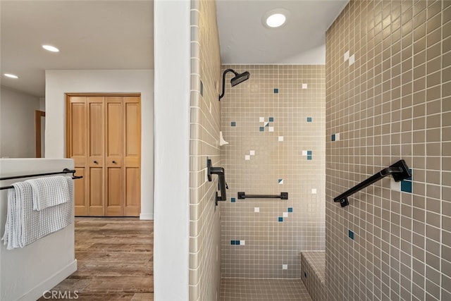 bathroom featuring hardwood / wood-style flooring and a tile shower