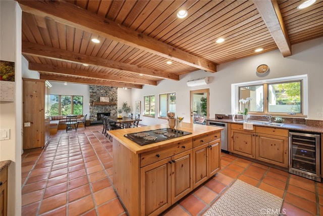 kitchen featuring a fireplace, black gas cooktop, wine cooler, and a wealth of natural light