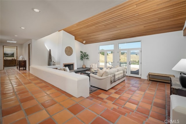 tiled living room with french doors, wood ceiling, and a large fireplace