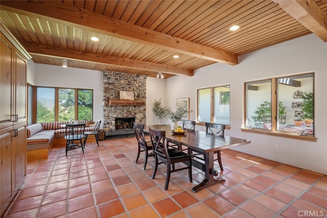 tiled dining space with wooden ceiling, a fireplace, and beamed ceiling