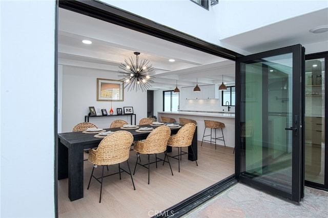 dining space with a chandelier, light hardwood / wood-style floors, and sink