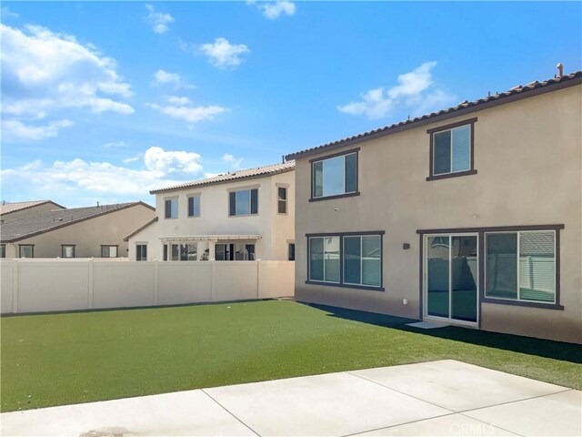 back of house featuring a yard and a patio