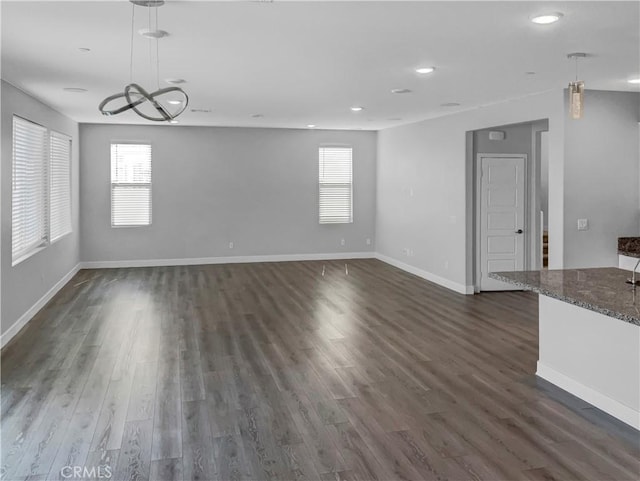 unfurnished living room featuring dark hardwood / wood-style floors and a healthy amount of sunlight