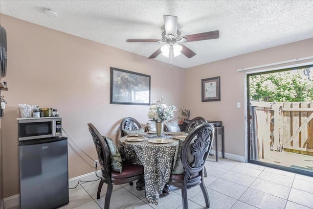 dining space with a textured ceiling, ceiling fan, and light tile patterned floors