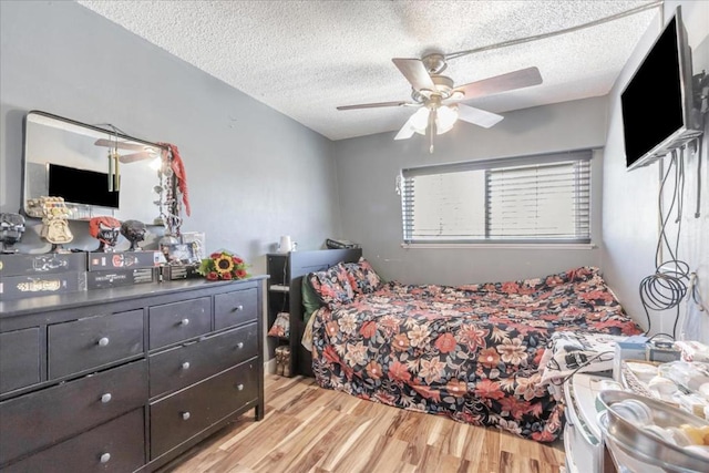 bedroom featuring a textured ceiling, ceiling fan, and light hardwood / wood-style flooring