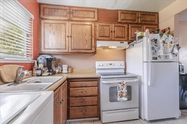 kitchen featuring light tile patterned flooring, sink, washer / clothes dryer, and white appliances