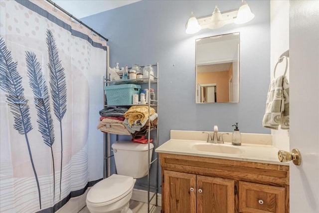 bathroom featuring toilet, vanity, and walk in shower