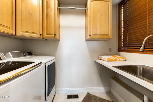 washroom with cabinets, independent washer and dryer, light tile patterned floors, and sink