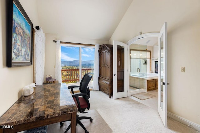 carpeted office space featuring vaulted ceiling, a mountain view, and french doors