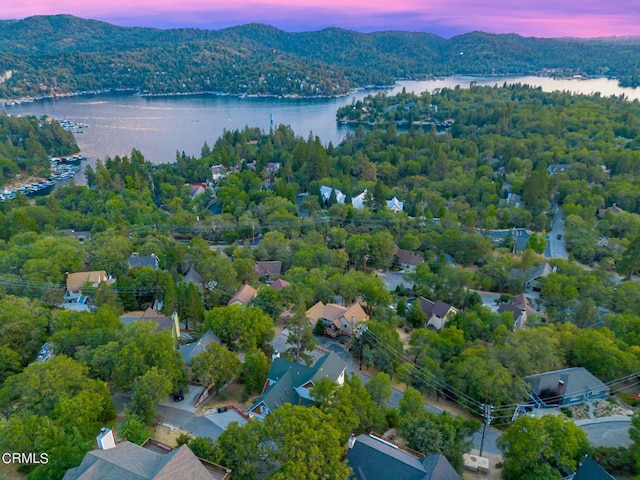 aerial view at dusk featuring a water view