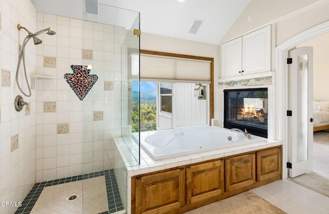 bathroom featuring shower with separate bathtub, lofted ceiling, a multi sided fireplace, and tile patterned flooring