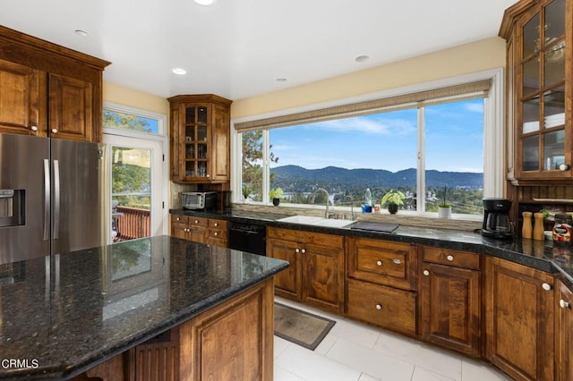 kitchen featuring a mountain view, light tile patterned flooring, stainless steel fridge, sink, and dishwasher