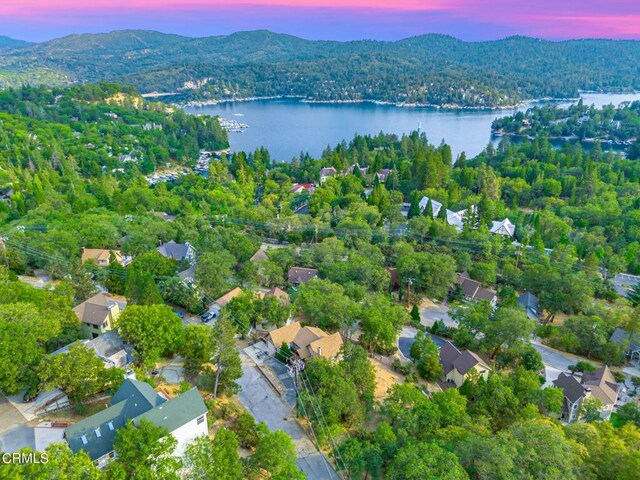 aerial view at dusk featuring a water and mountain view