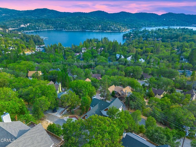 aerial view at dusk featuring a water and mountain view