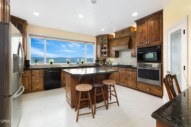 kitchen with a mountain view, a kitchen island, backsplash, appliances with stainless steel finishes, and custom range hood