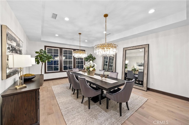 dining area featuring an inviting chandelier and light hardwood / wood-style floors