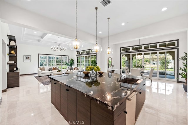 kitchen featuring dark brown cabinets, a large island, stainless steel dishwasher, and a wealth of natural light