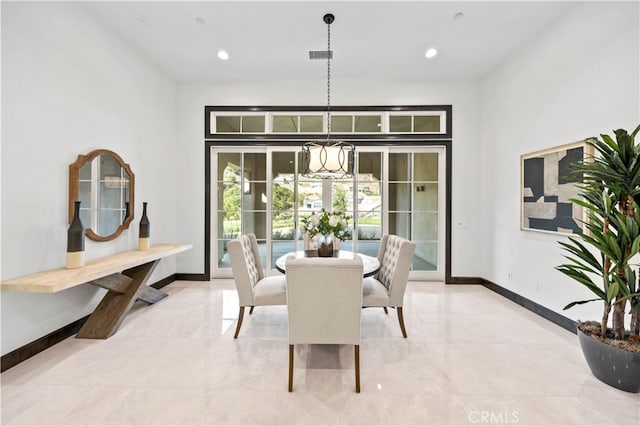 tiled dining room with a chandelier