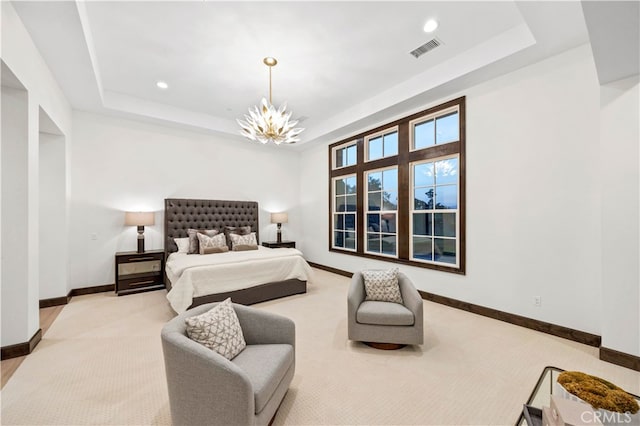 carpeted bedroom featuring a notable chandelier and a raised ceiling