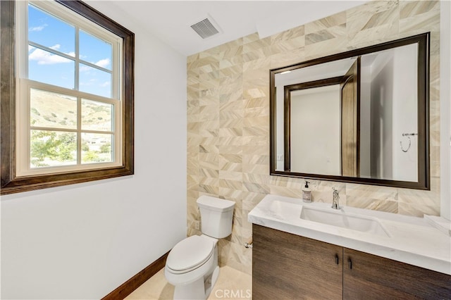 bathroom with tile walls, vanity, and toilet