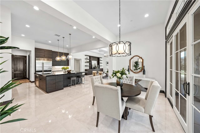 dining room featuring beamed ceiling and sink