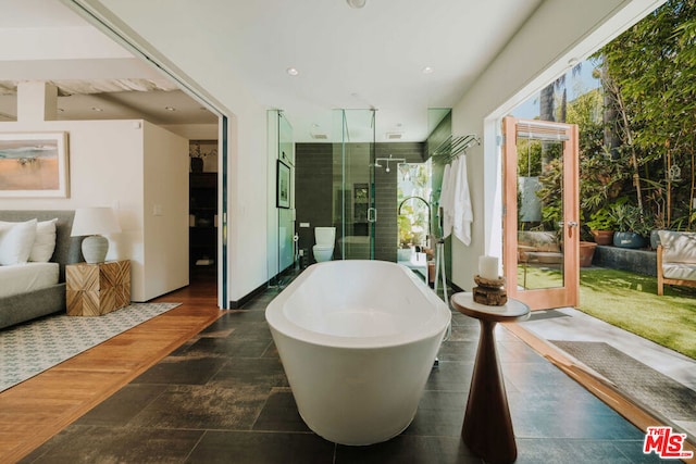 bathroom featuring shower with separate bathtub and hardwood / wood-style floors