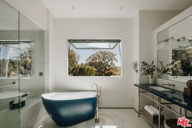 bathroom with plus walk in shower, vanity, and a healthy amount of sunlight