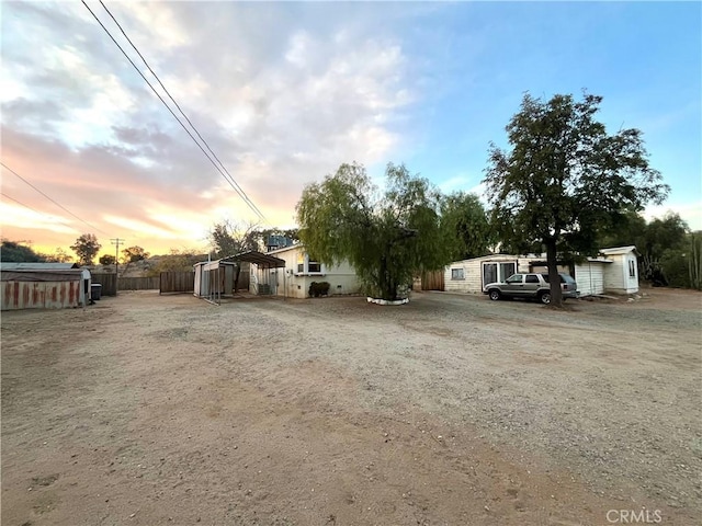 yard at dusk featuring a carport