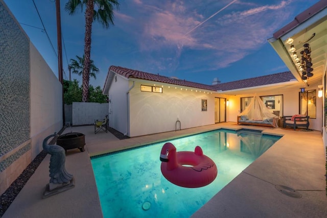 pool at dusk with a patio