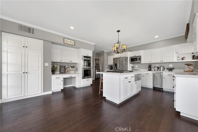 kitchen featuring white cabinets, dark hardwood / wood-style flooring, a kitchen island, and decorative light fixtures