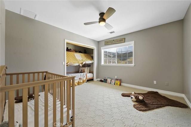 bedroom featuring ceiling fan, carpet floors, and a nursery area