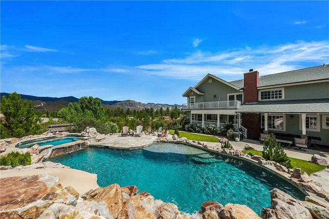 view of pool featuring an in ground hot tub, a mountain view, and a patio