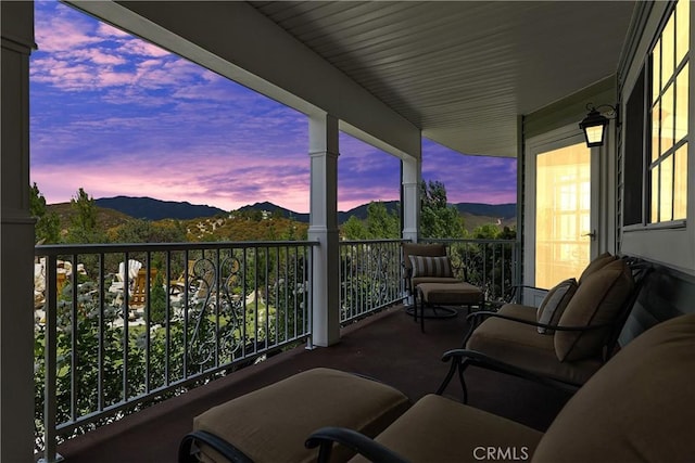 balcony at dusk featuring a mountain view