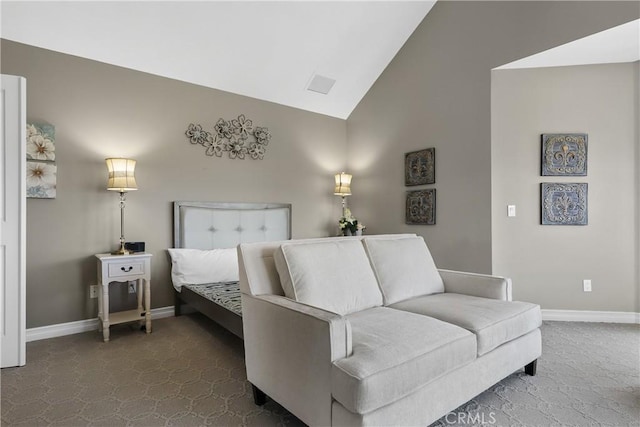 bedroom featuring dark colored carpet and high vaulted ceiling