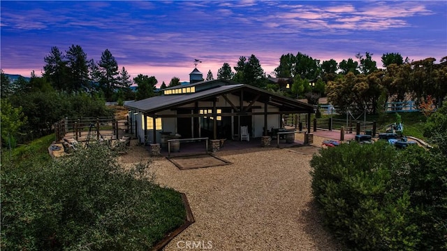 back house at dusk with an outdoor structure