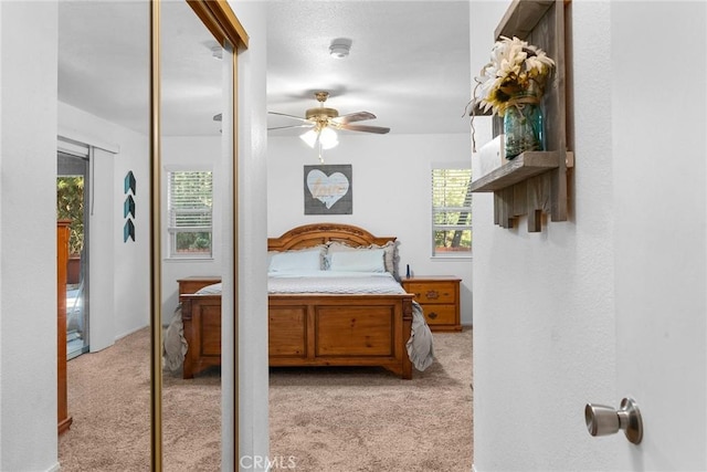 carpeted bedroom featuring ceiling fan and multiple windows