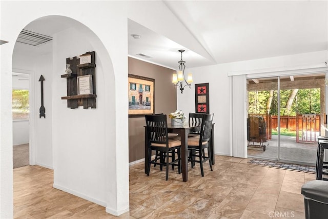 dining space featuring lofted ceiling and an inviting chandelier