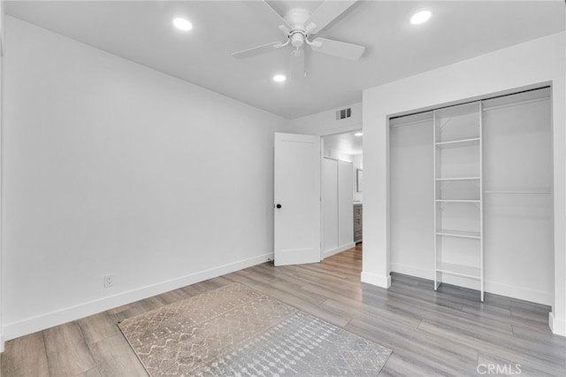 unfurnished bedroom with a closet, light wood-type flooring, and ceiling fan